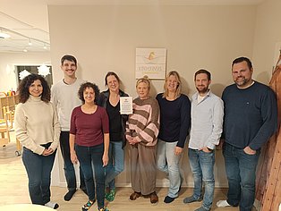 Männer und Frauen vor einer beigen Wand